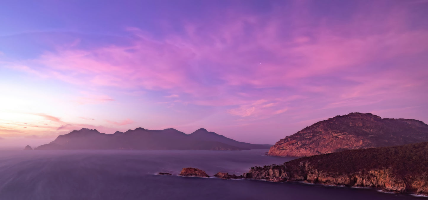 Beautiful pre-dawn clouds over Wineglass Bay near Freycenet in Tasmania, Australia reveal a hidden gem. I took the shot to capture the helicopter but the long exposure captured the amazing colors of the sky.