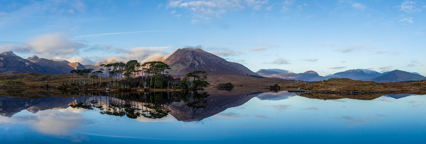The last rays of a winter sun bath a beautiful panorama of Pines Island reflected in the waters of Derryclare Lough near Clifden, County Galway, Ireland.  Taken from the water's edge after scrambling down the embankment from a nearby road.
